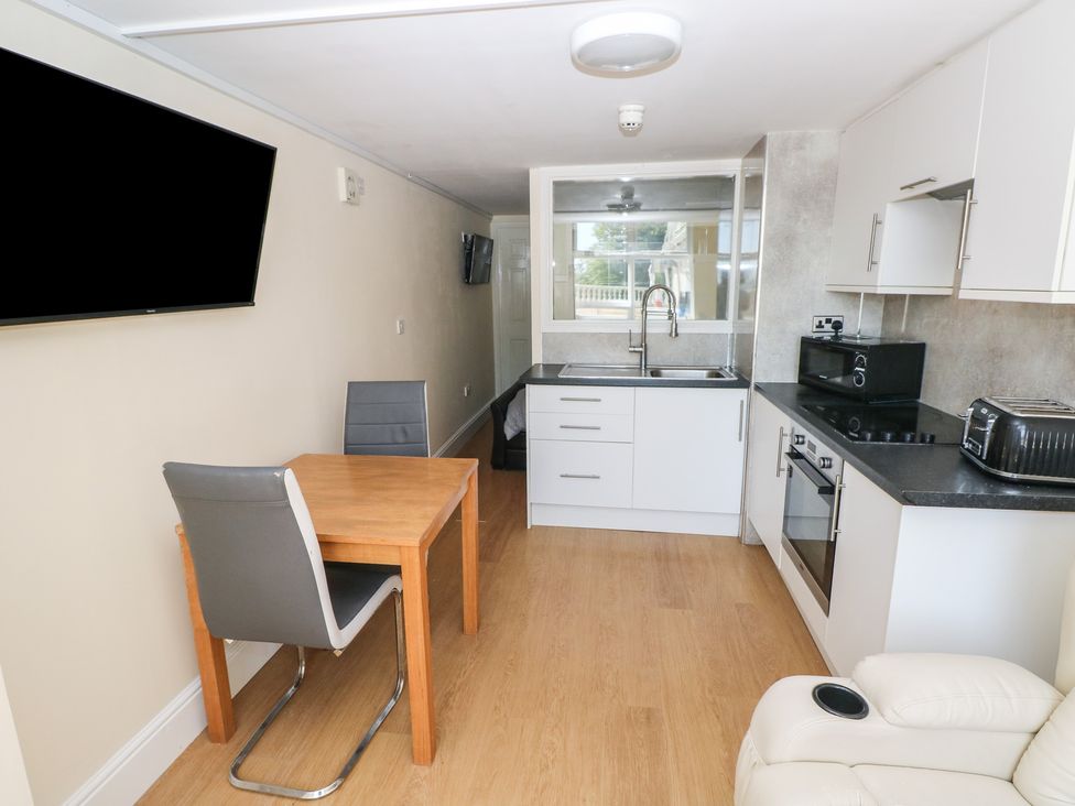 A kitchen with a dining table and chairs at Whiteshell in Langland near Mumbles