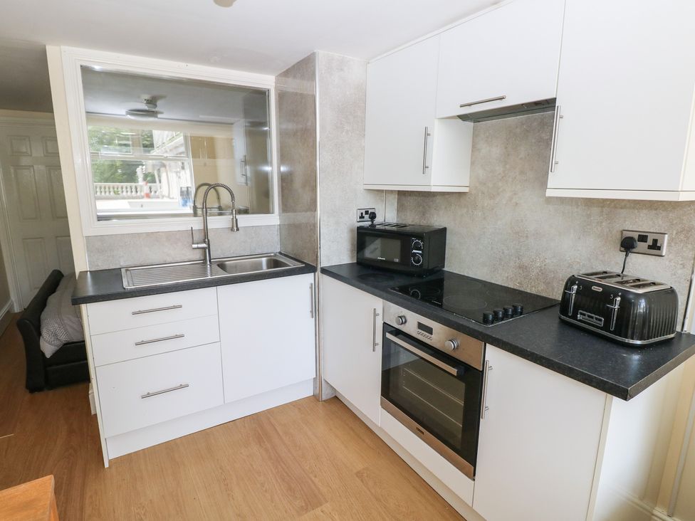 A kitchen with sink, cabinets, and appliances at Whiteshell in Langland near Mumbles