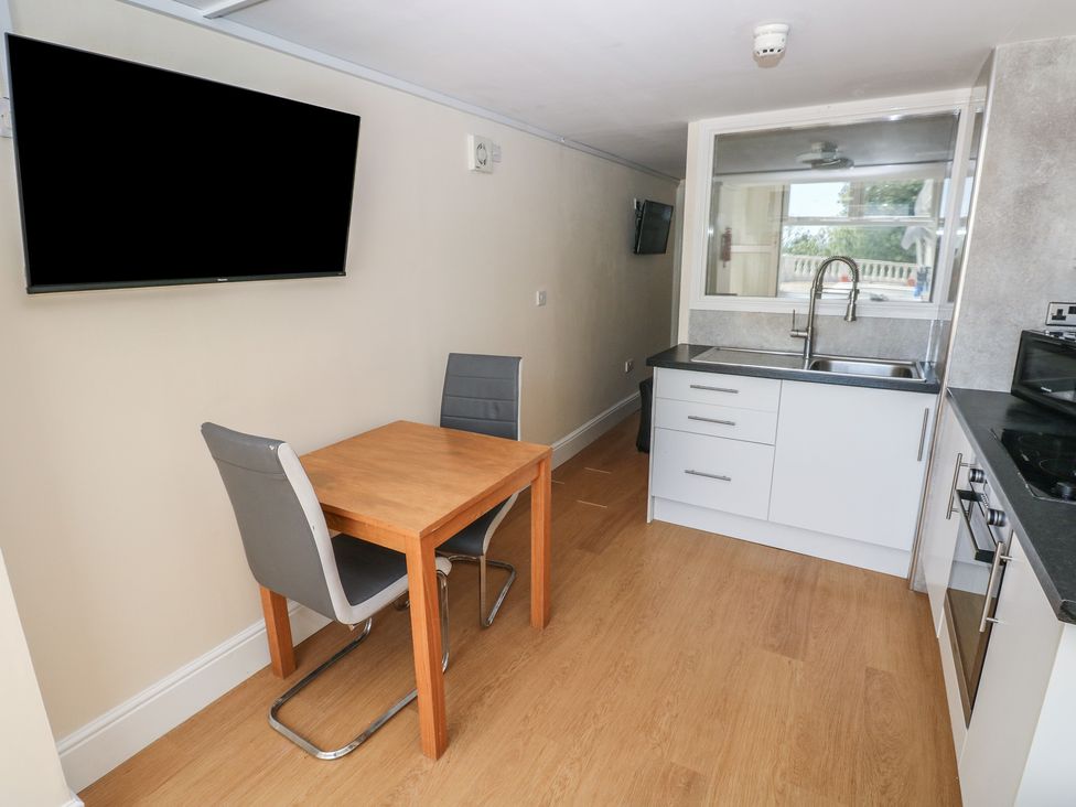 A kitchen with a dining table and chairs at Whiteshell in Langland near Mumbles