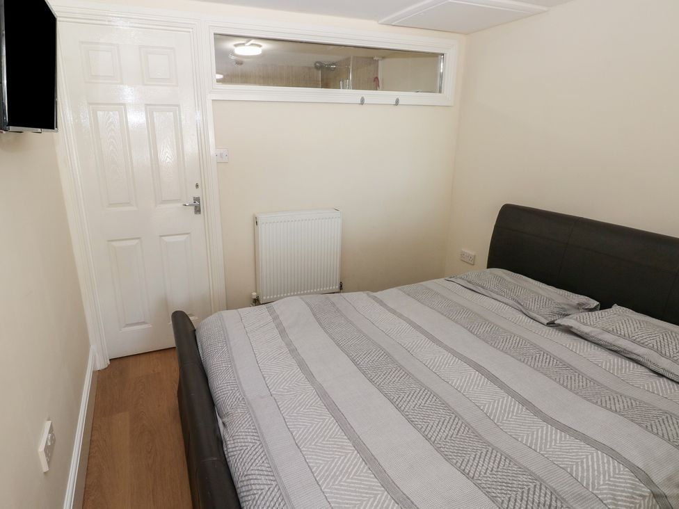 A bedroom with a bed and television at Whiteshell in Langland near Mumbles