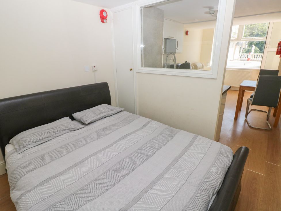 A bedroom with a bed and a kitchenette visible at Whiteshell in Langland near Mumbles