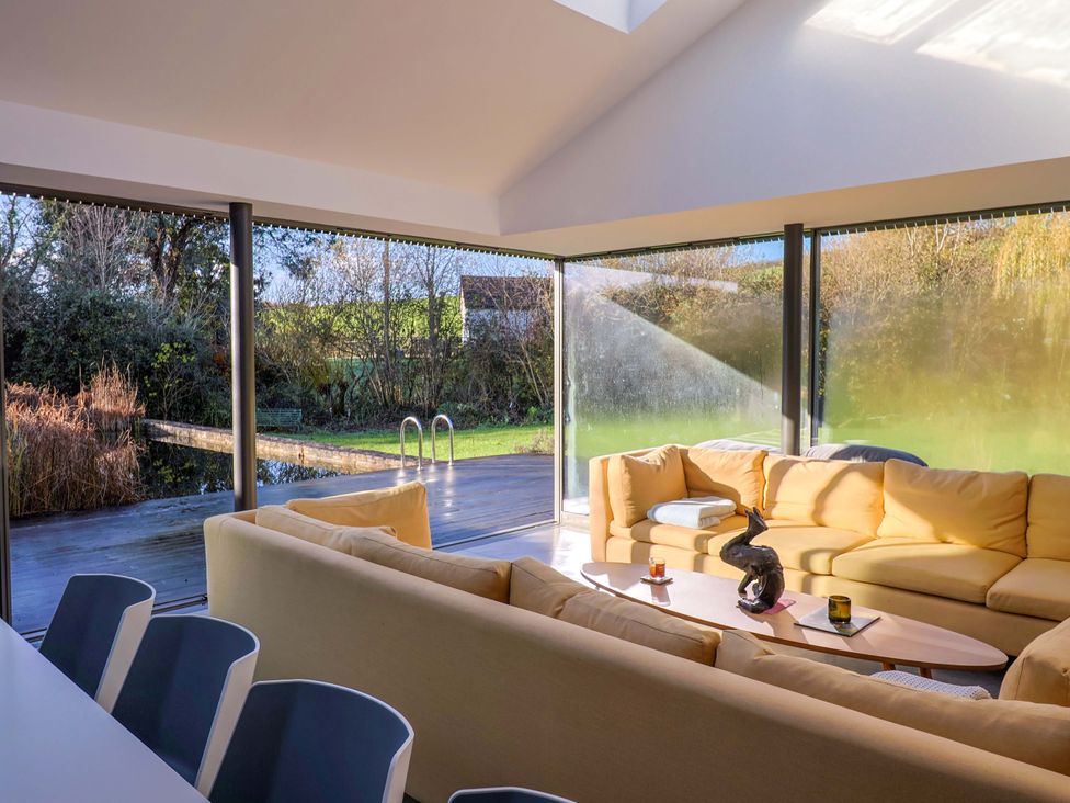 A living room with a sofa and table at 2 Bredy Cottages in Burton Bradstock