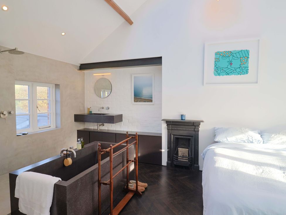 A bathroom with a bathtub and sink at 2 Bredy Cottages in Burton Bradstock