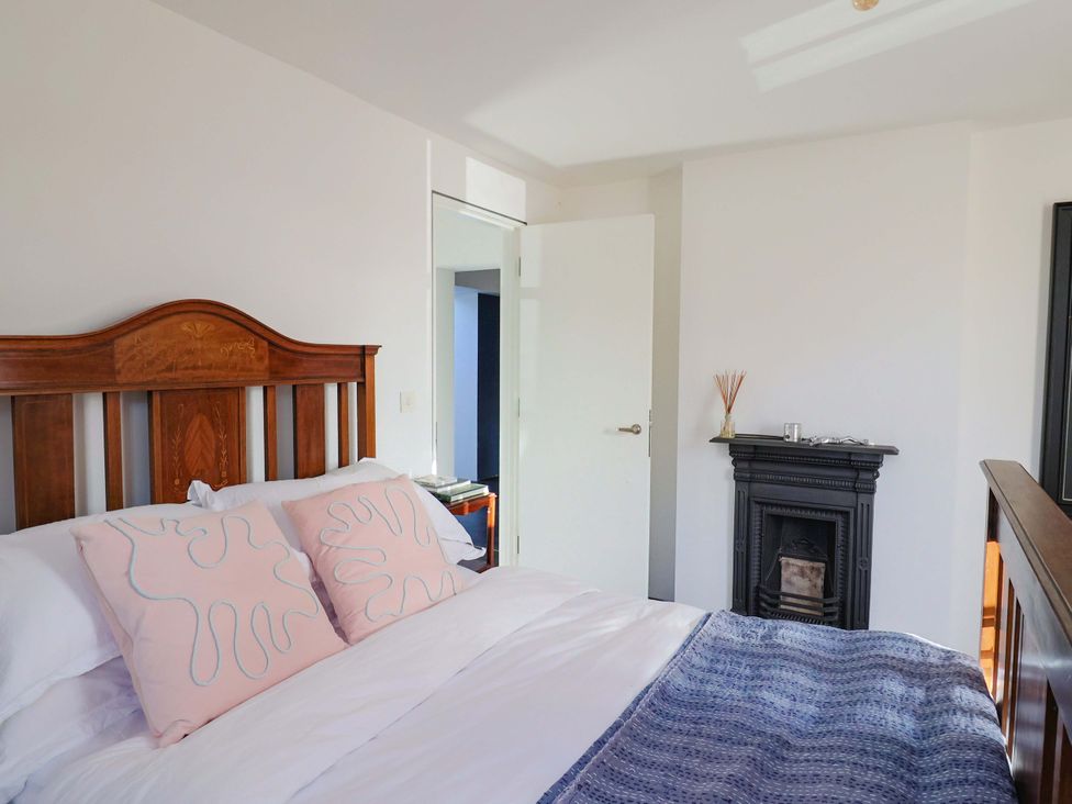 A bedroom with a bed and fireplace at 2 Bredy Cottages in Burton Bradstock