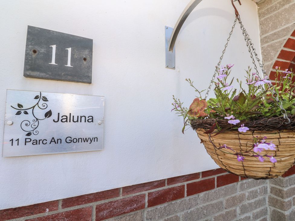 A number and name plaque with a flower basket at Jaluna in Carbis Bay