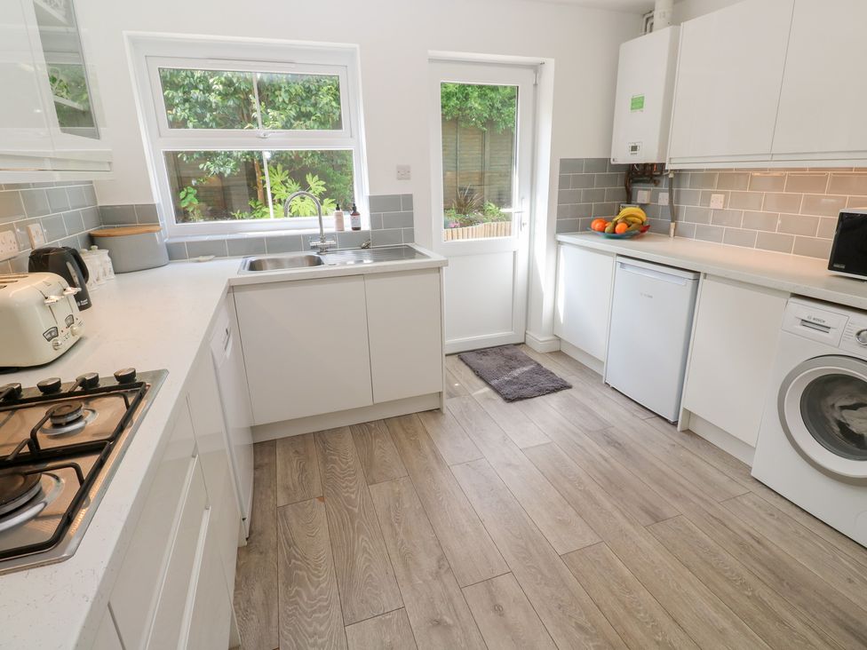 A kitchen with appliances and a view of the garden at Jaluna in Carbis Bay