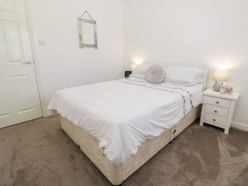 A bedroom with a bed and nightstand at Jaluna in Carbis Bay