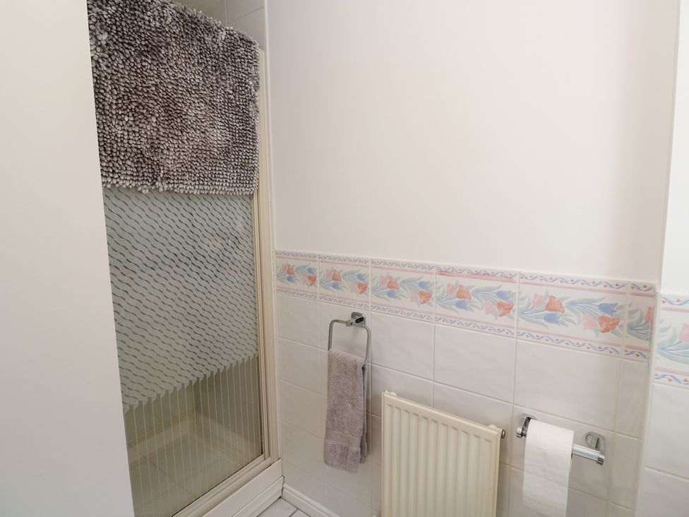 A bathroom with a shower and towels at Jaluna in Carbis Bay