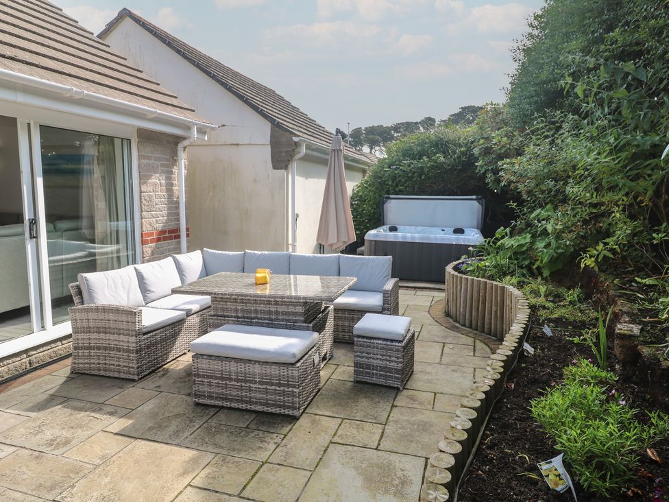 A garden with outdoor furniture and a hot tub at Jaluna in Carbis Bay