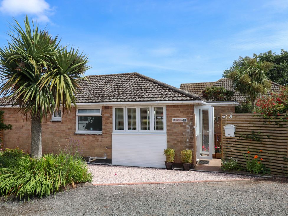 A house entrance with plants and a gravel driveway at Rowan in Brixham