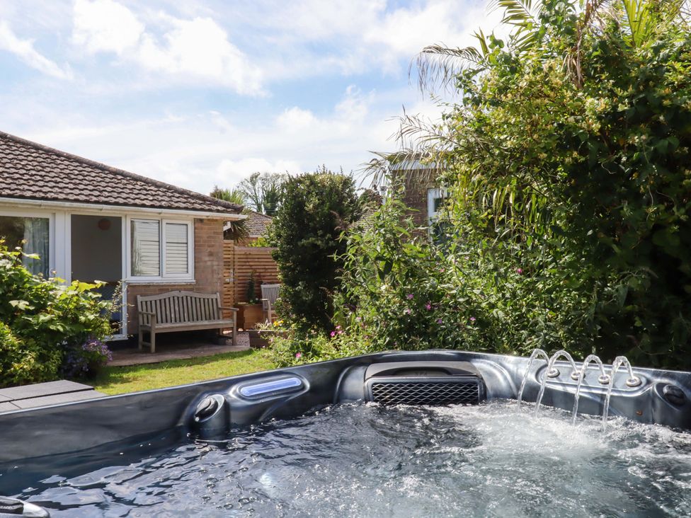 A garden with a hot tub and seating area at Rowan in Brixham