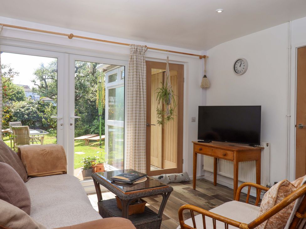 A snug with a sofa and television at Rowan in Brixham