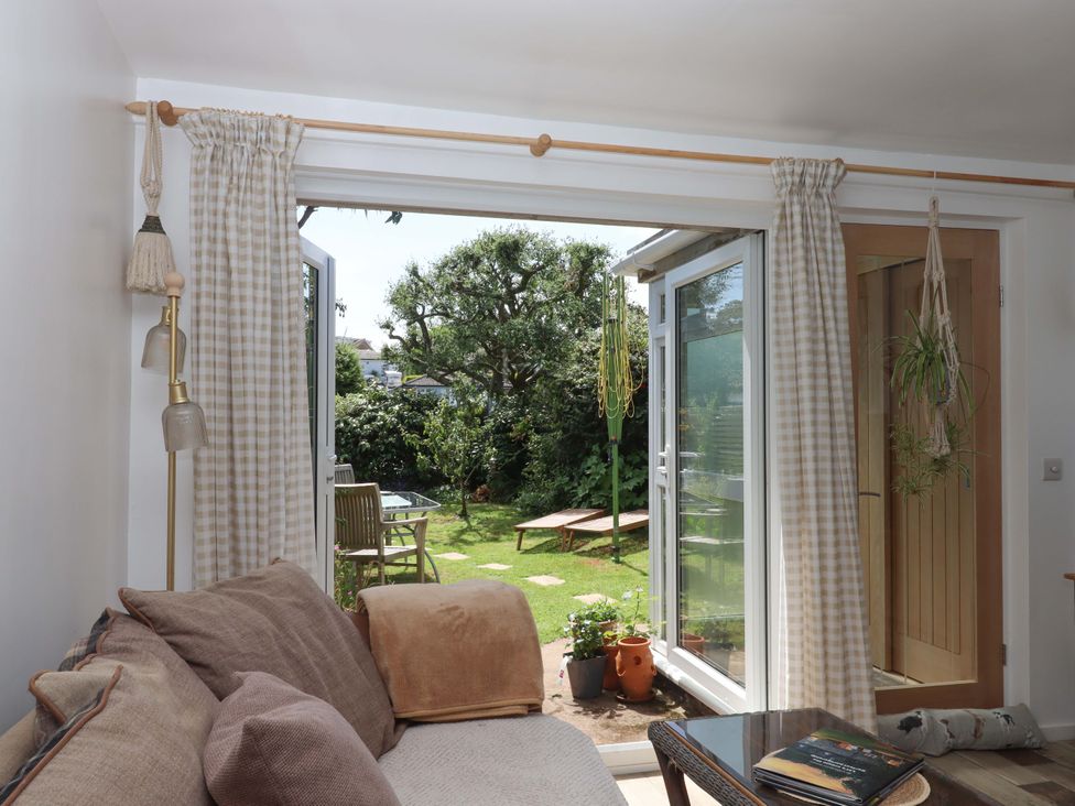 A living room with a view of the garden at Rowan in Brixham