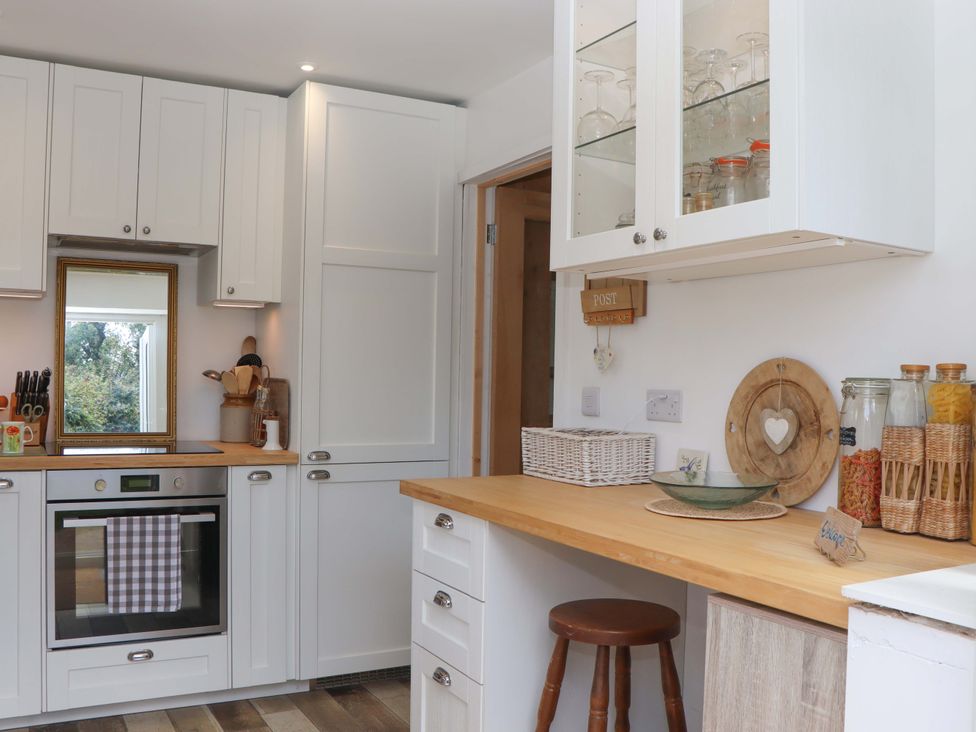 A kitchen with cabinets and an oven at Rowan in Brixham