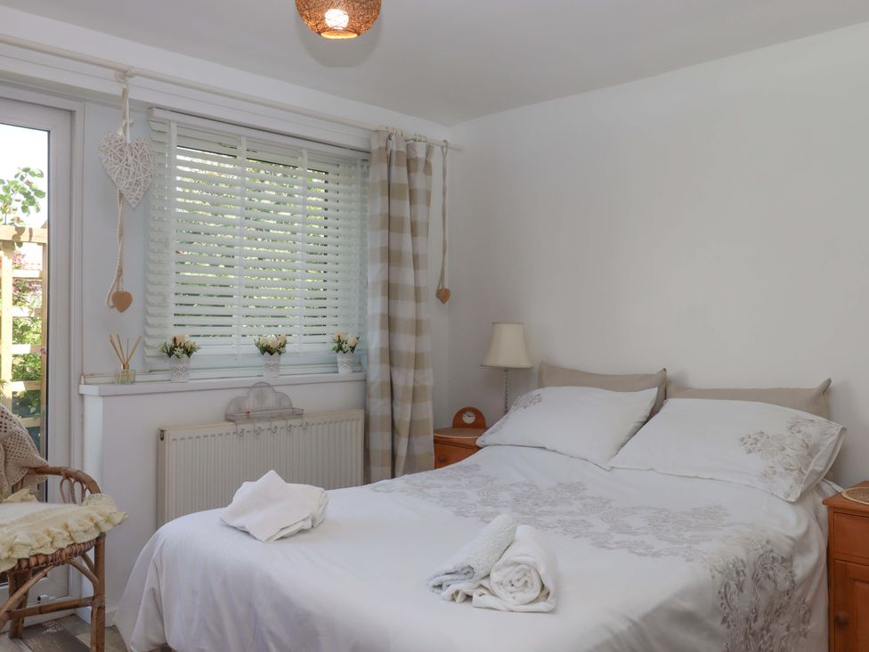 A bedroom with a bed and bedside table at Rowan in Brixham