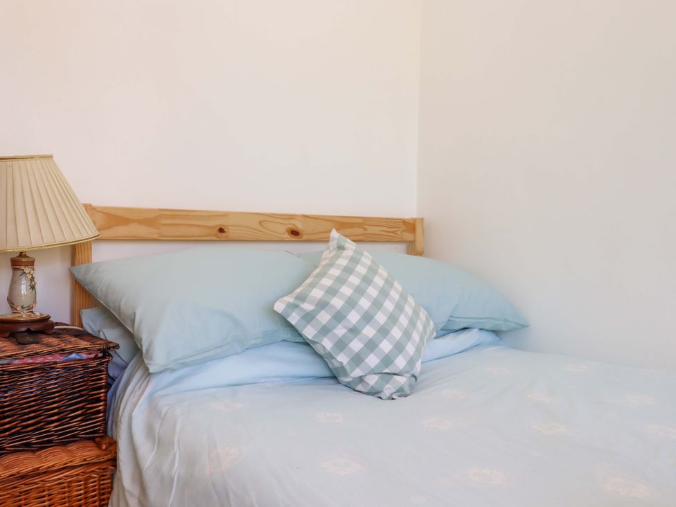 A bedroom with a bed and lamp at Rowan in Brixham