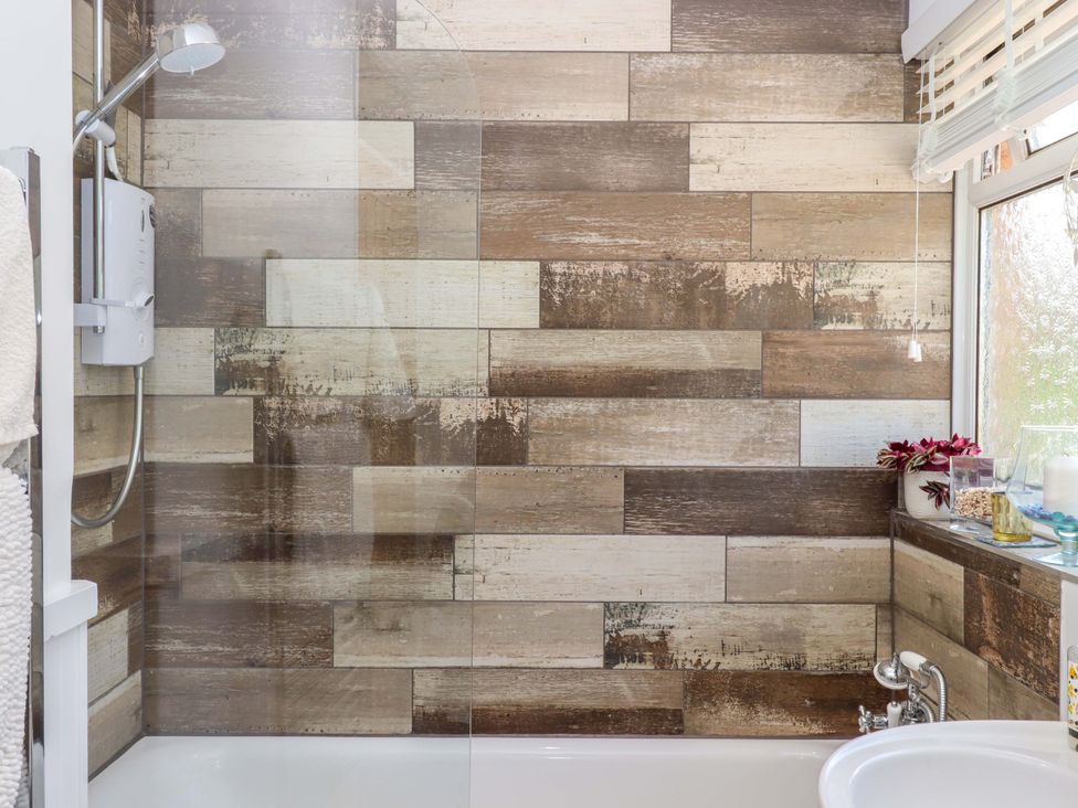 A bathroom with a shower and bathtub at Rowan in Brixham