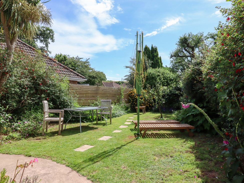 A garden with a table and chairs at Rowan in Brixham