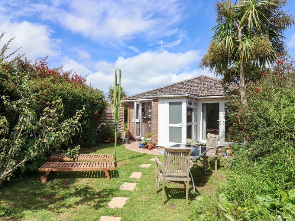 A garden with furniture and plants at Rowan in Brixham