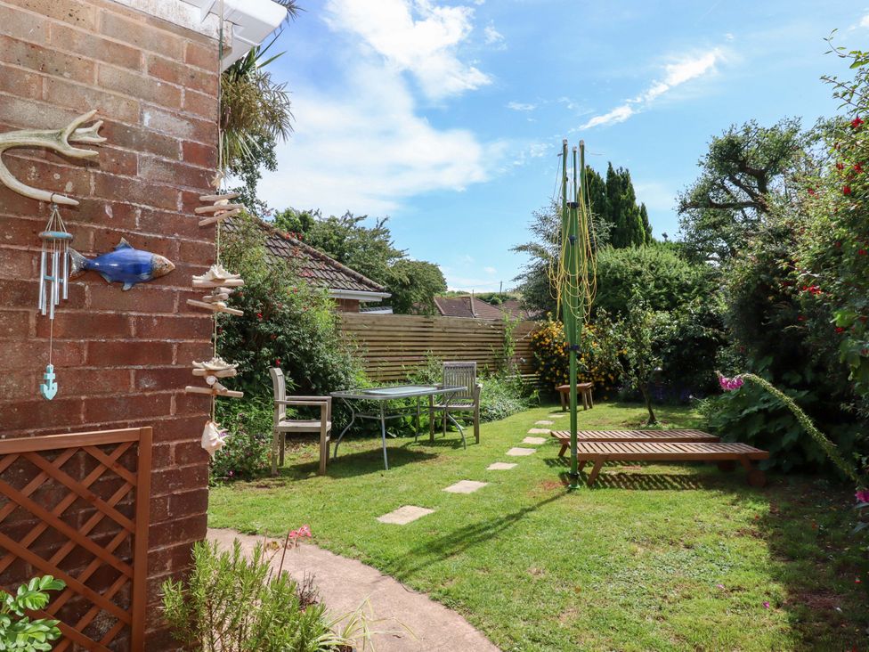 A garden with a table and chairs at Rowan in Brixham