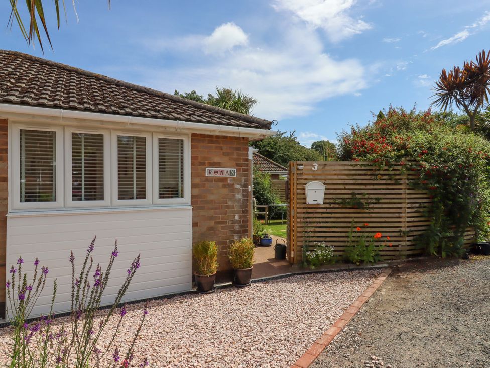 An outdoor view of a house with a path and garden at Rowan in Brixham