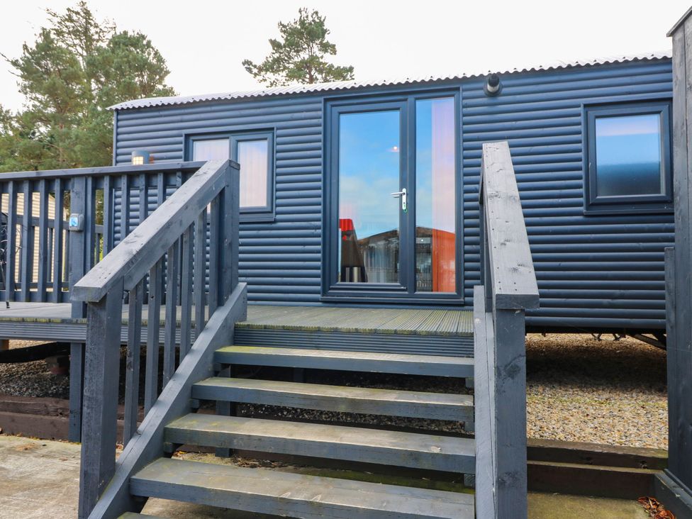 An exterior view of a cabin with steps and a deck at Ava Lodge in West Mains near Haggerston
