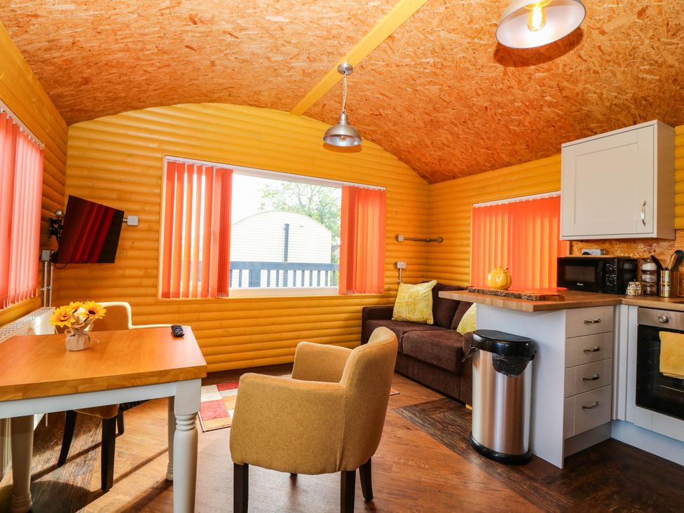 A living room with a sofa and table at Ava Lodge in West Mains near Haggerston