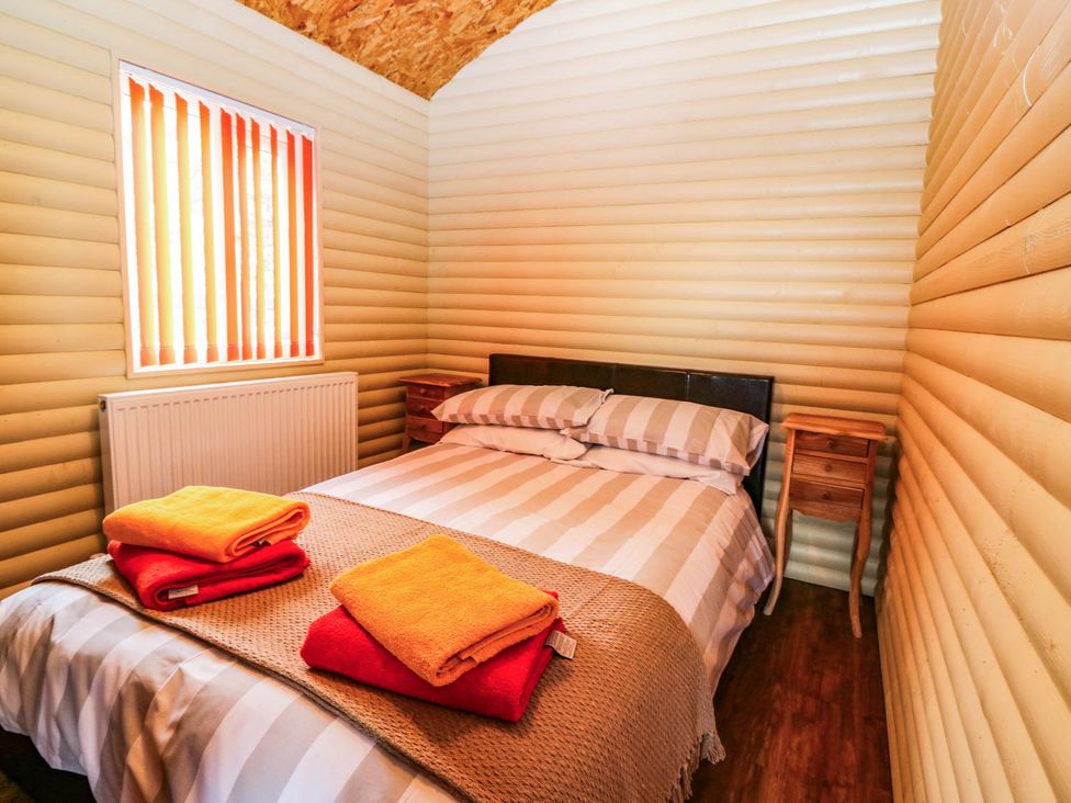 A bedroom with a bed and towels at Ava Lodge in West Mains near Haggerston