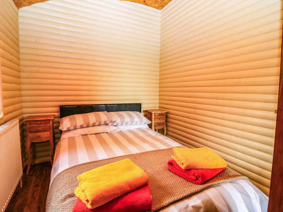 A bedroom with a bed and side tables at Ava Lodge West Mains near Haggerston