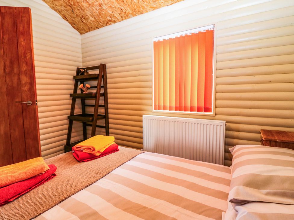 A bedroom with a bed and shelf at Ava Lodge West Mains near Haggerston