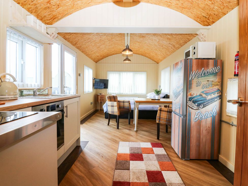 A kitchen with a table and chairs at Masons Hut near Haggerston