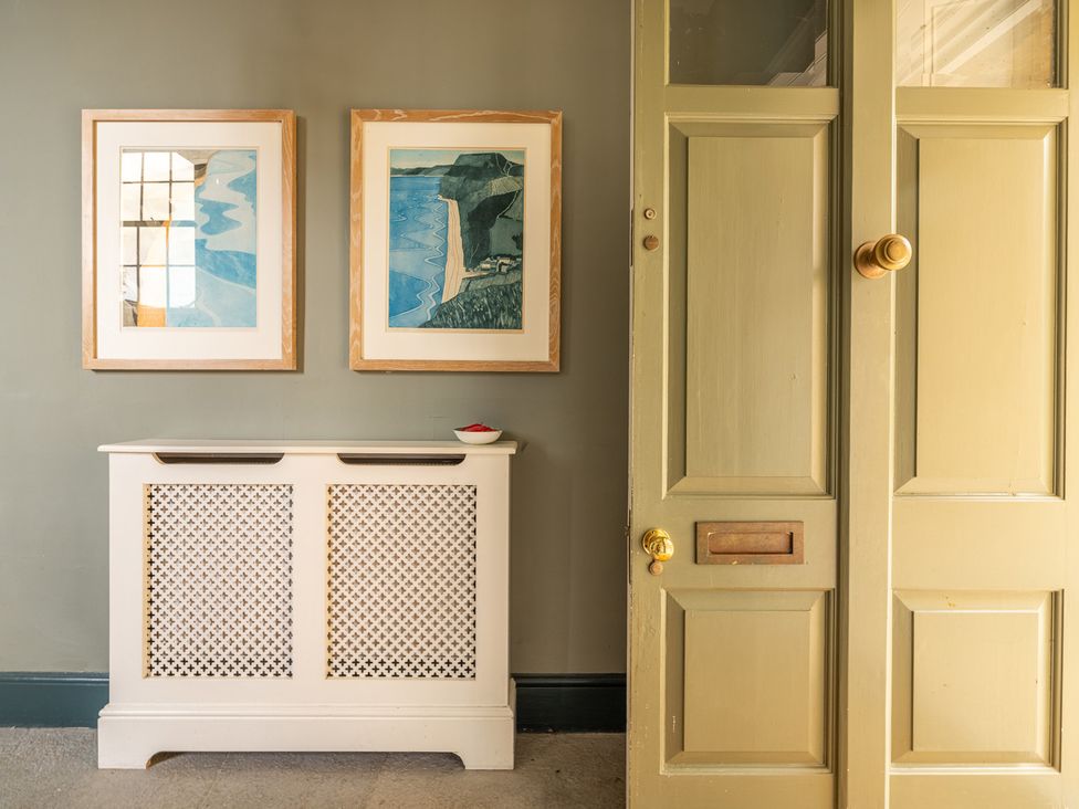 A hallway with wall art and a radiator cover at The Old Vicarage in Merriott