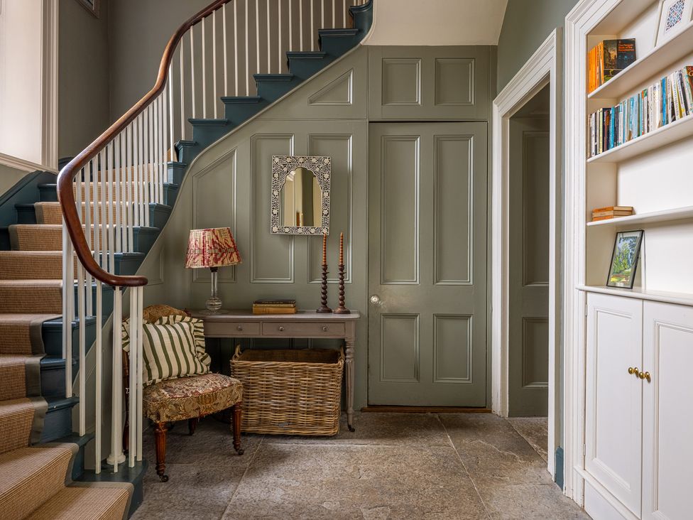 A hallway with stairs and a console table at The Old Vicarage in Merriott