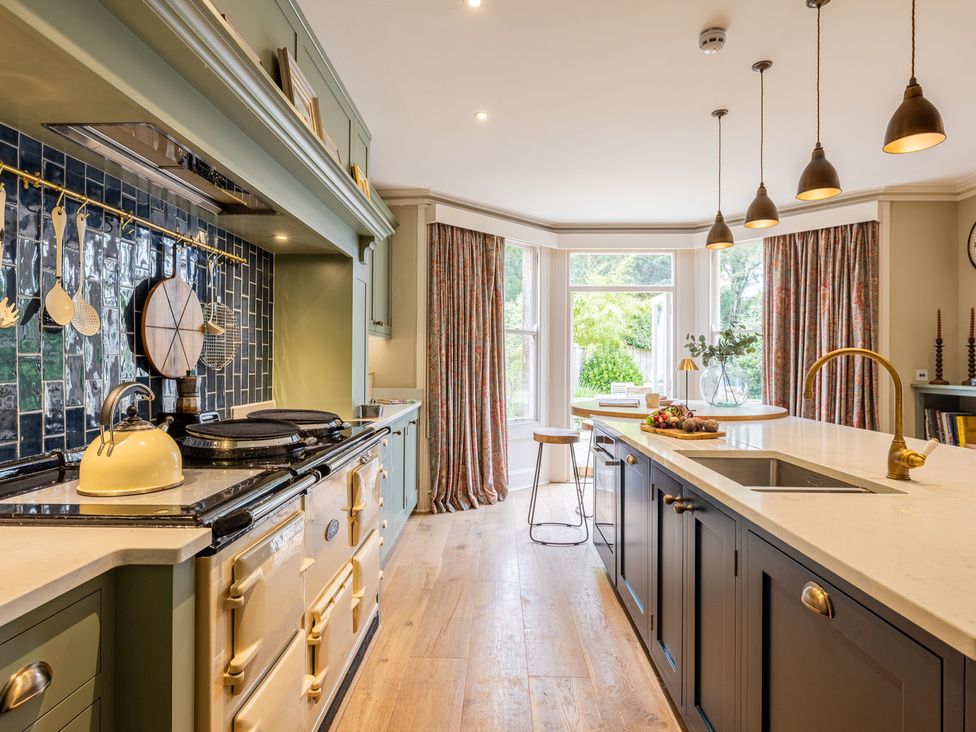 A kitchen with an island and bar stool at The Old Vicarage in Merriott