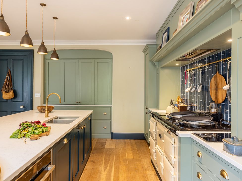 A kitchen with an island and cooking range at The Old Vicarage in Merriott