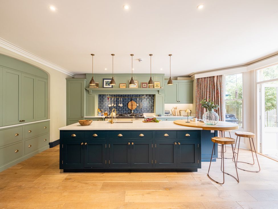 A kitchen with an island and stools at The Old Vicarage in Merriott
