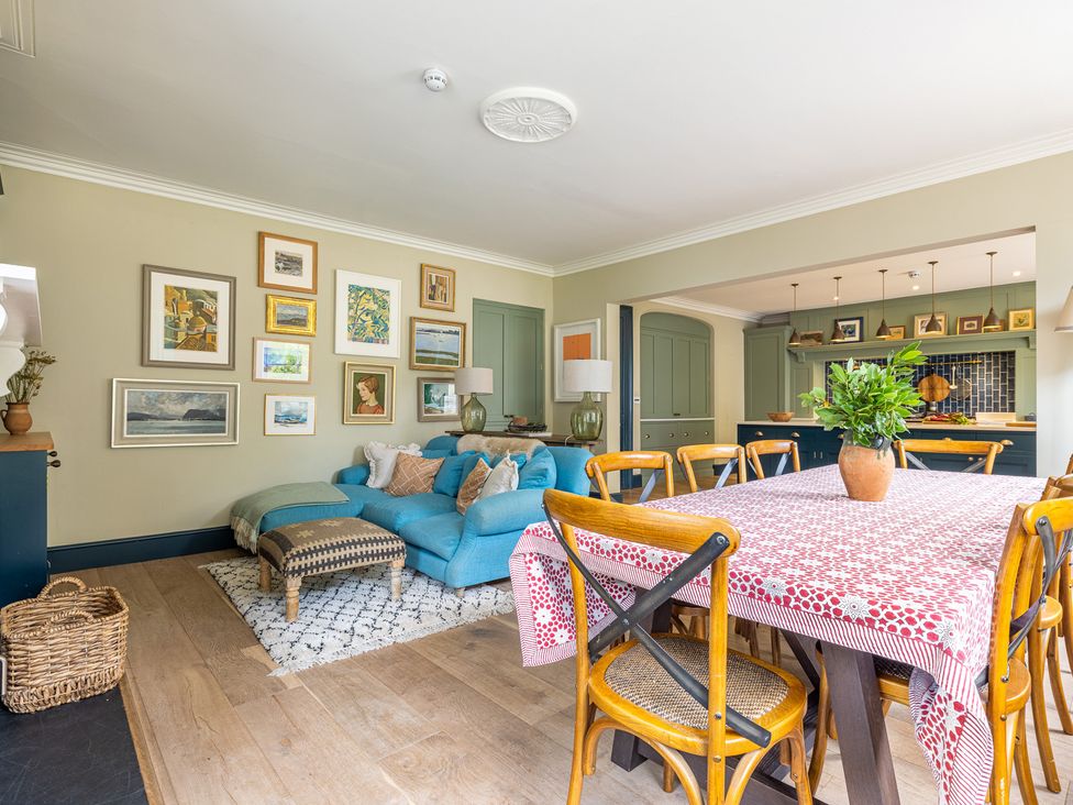 A living room with a sofa and dining table at The Old Vicarage in Merriott
