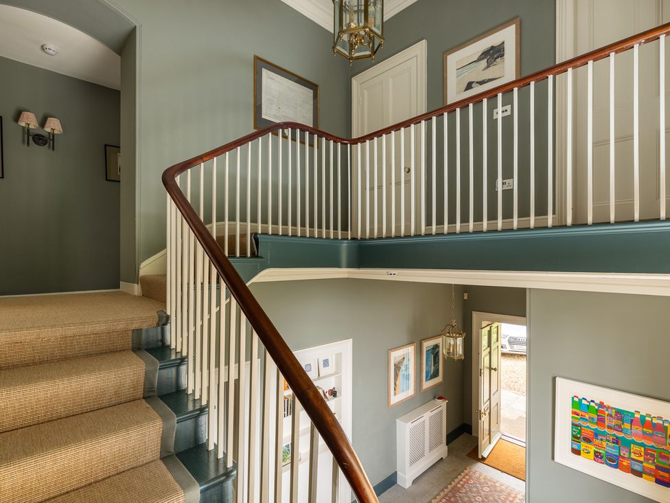 A hallway with a staircase and door at The Old Vicarage in Merriott