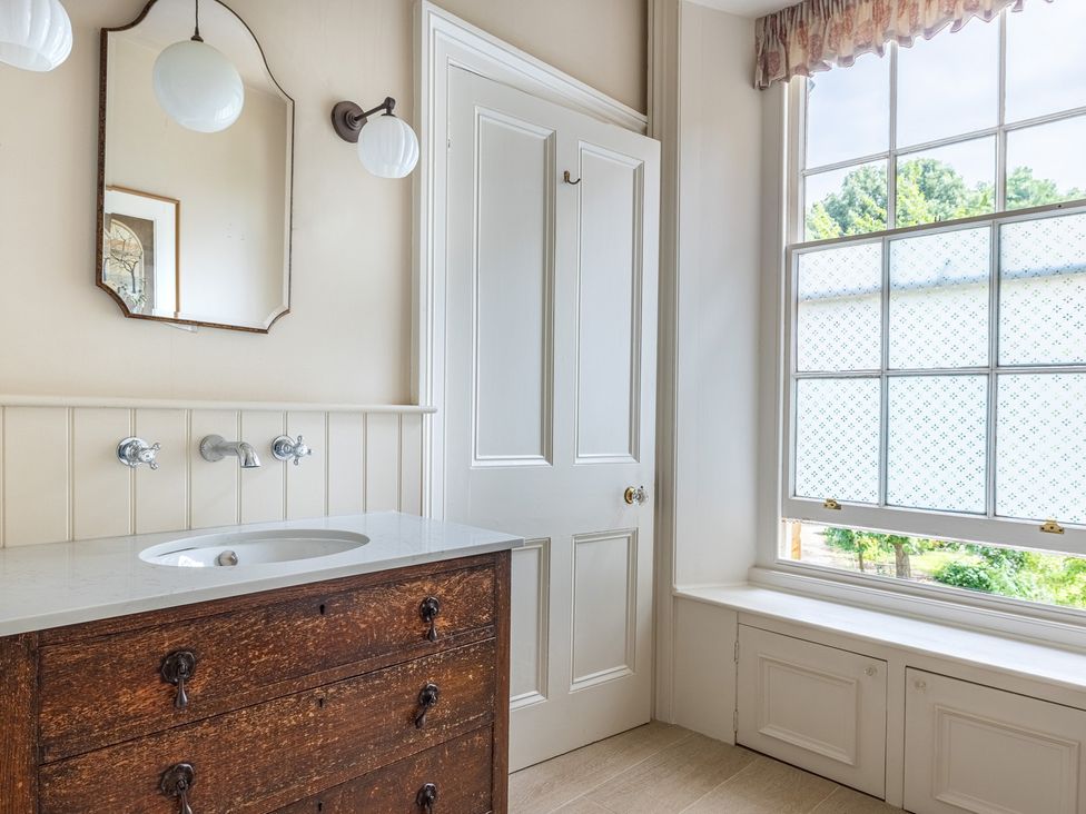 A bathroom with a wash basin and window at The Old Vicarage in Merriott