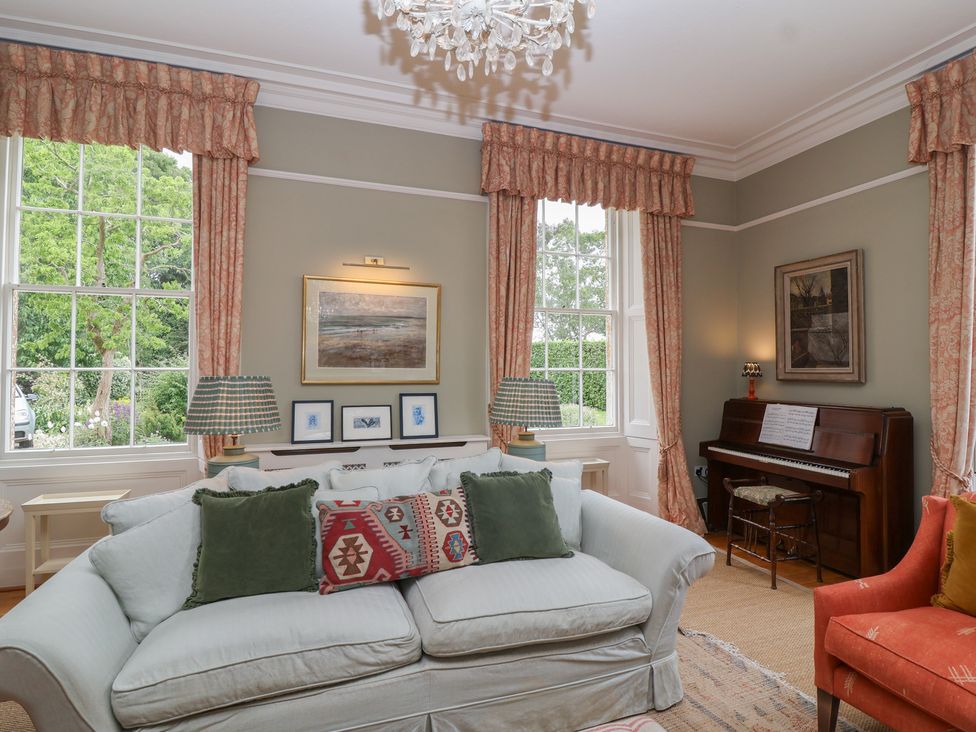 A living room with a piano and a sofa at The Old Vicarage in Merriott