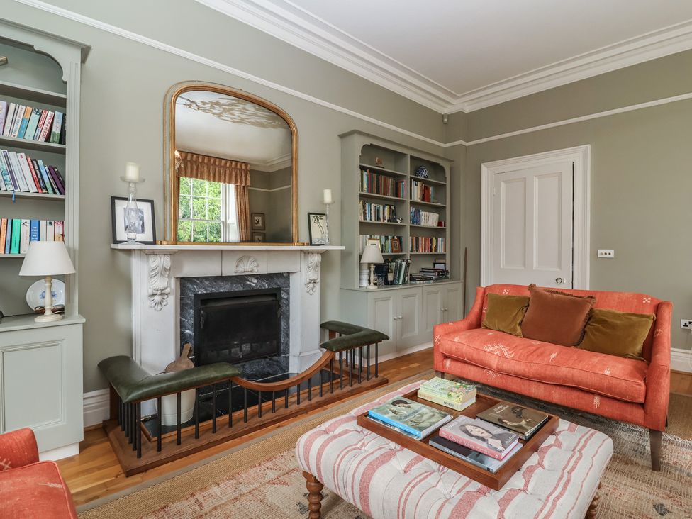 A living room with a fireplace and bookshelf at The Old Vicarage in Merriott
