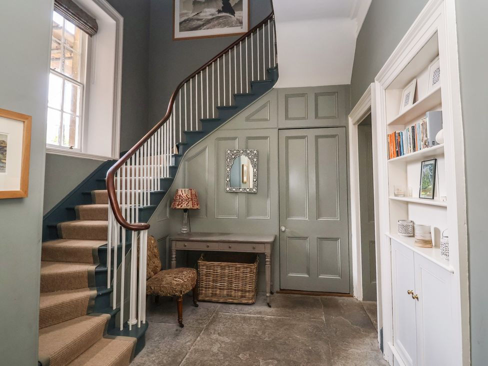 A hallway with stairs and a mirror at The Old Vicarage in Merriott