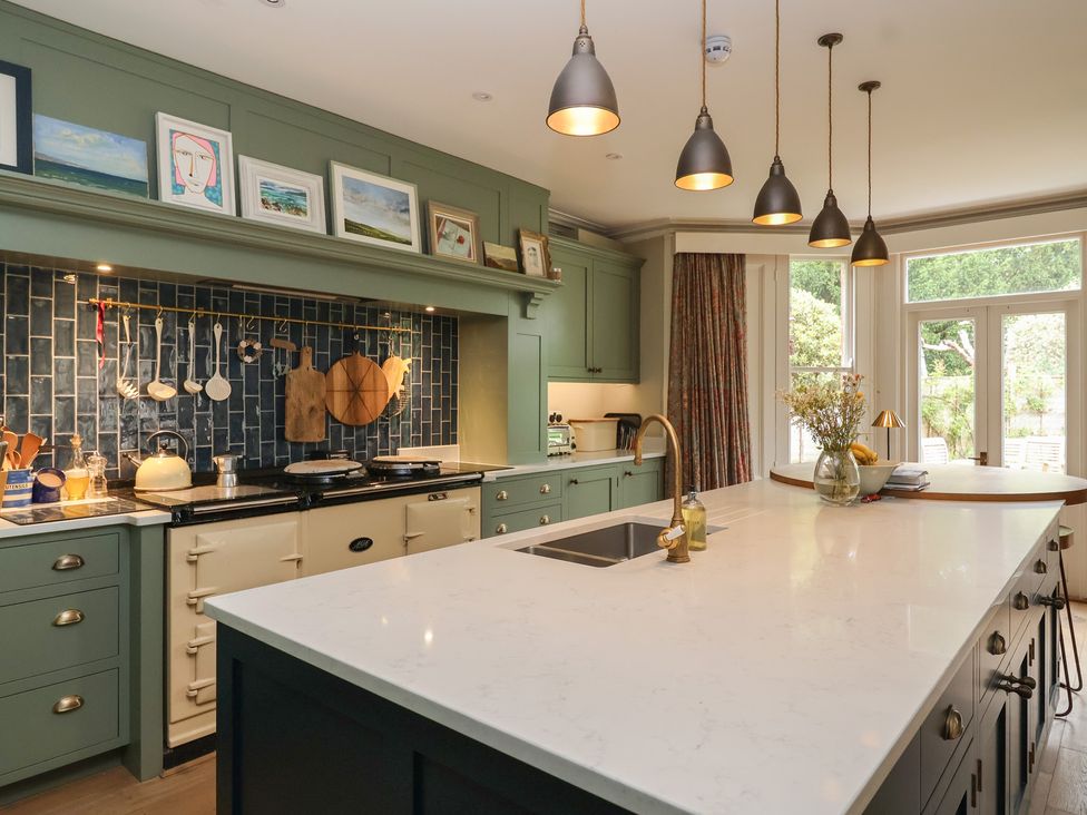 A kitchen with a central island and cooking stove at The Old Vicarage in Merriott