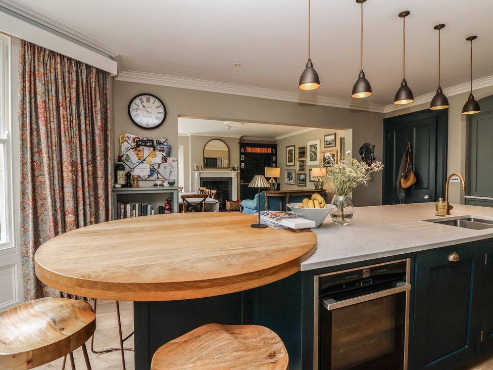 A kitchen with a round dining table and shelves at The Old Vicarage in Merriott