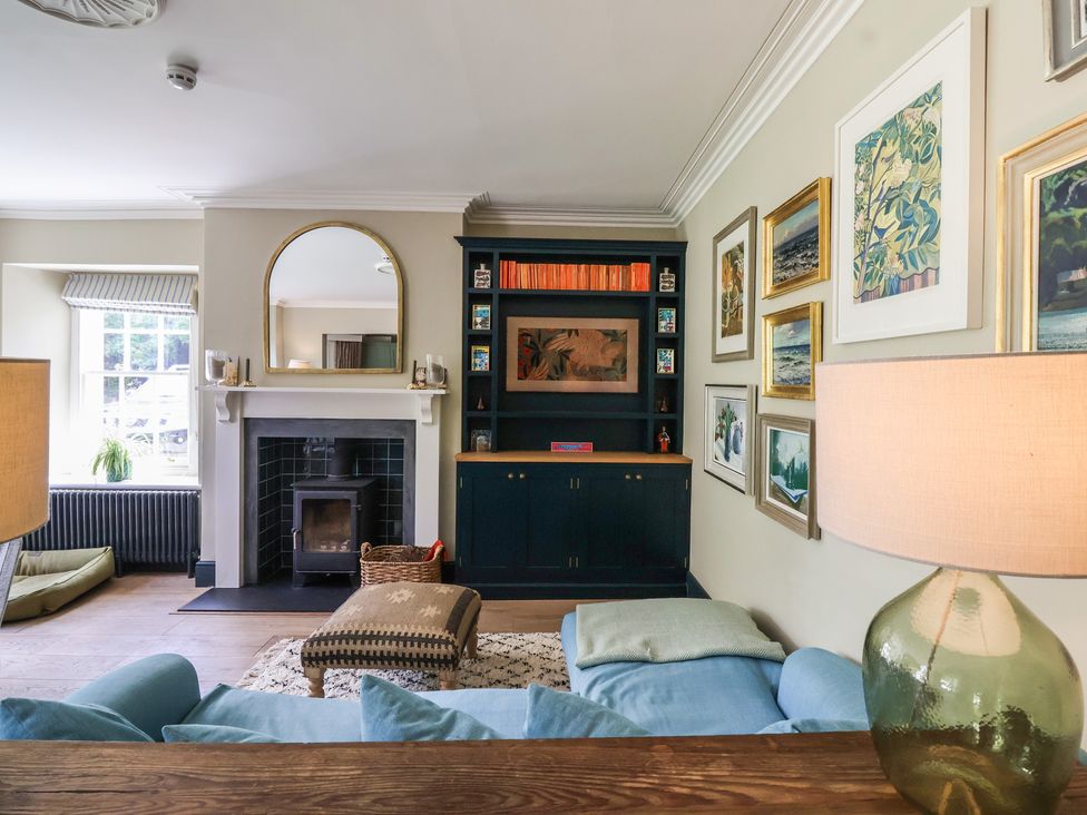 A living room with a fireplace and bookshelf at The Old Vicarage in Merriott