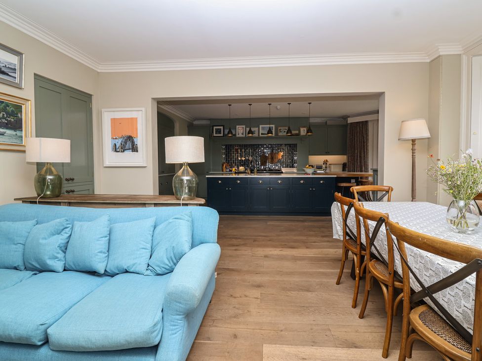 A dining room with a blue sofa and a table at The Old Vicarage in Merriott