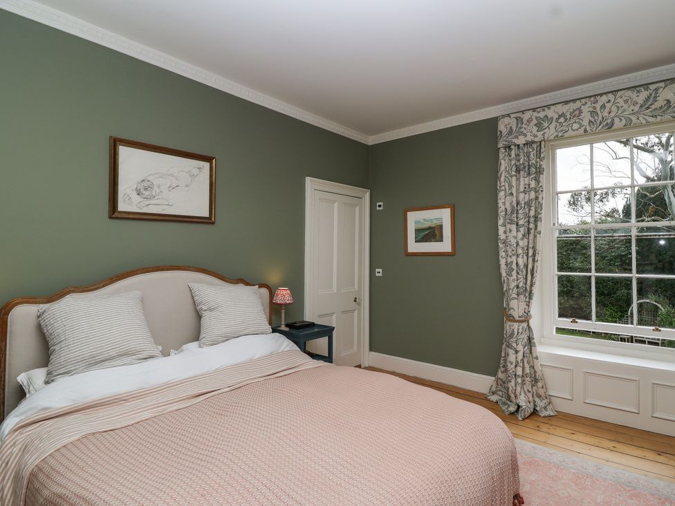 A bedroom with a bed and window at The Old Vicarage in Merriott