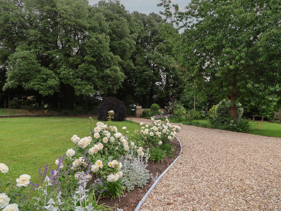 A garden with a gravel path and flowers at The Old Vicarage in Merriott