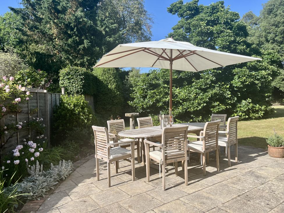 A garden with a table and chairs under an umbrella at The Old Vicarage in Merriott