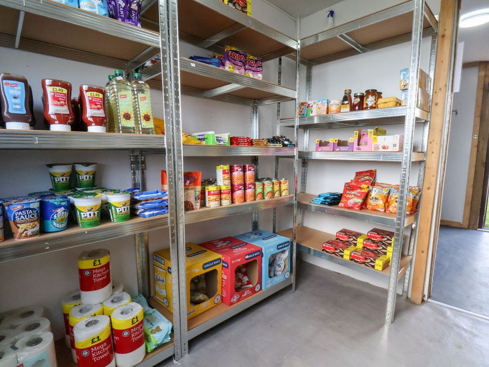 A pantry with shelves of various food and household items at Deer Pod Staintondale near Burniston